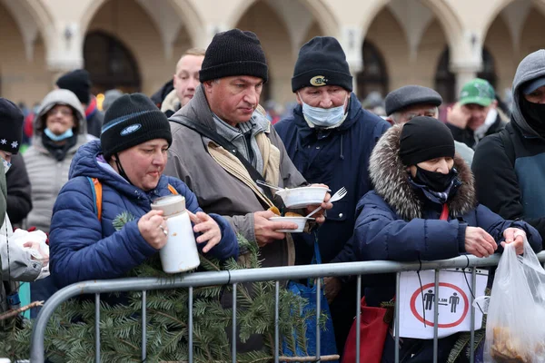 Krakow, Polonya - 19 Aralık 2021: Krakow 'daki ana meydandaki fakir ve evsizler için Noel arifesi. Covid salgınına rağmen Kosciuszko grubu Krakow 'daki açık havada en büyük arifeyi hazırlıyor.