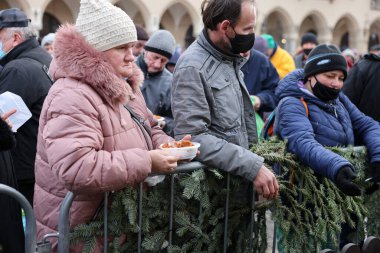 Krakow, Polonya - 19 Aralık 2021: Krakow 'daki ana meydandaki fakir ve evsizler için Noel arifesi. Covid salgınına rağmen Kosciuszko grubu Krakow 'daki açık havada en büyük arifeyi hazırlıyor.
