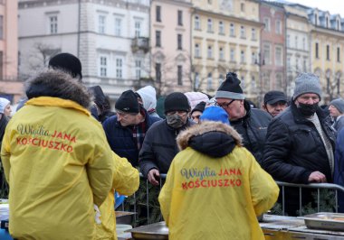 Krakow, Polonya - 19 Aralık 2021: Krakow 'daki ana meydandaki fakir ve evsizler için Noel arifesi. Covid salgınına rağmen Kosciuszko grubu Krakow 'daki açık havada en büyük arifeyi hazırlıyor.