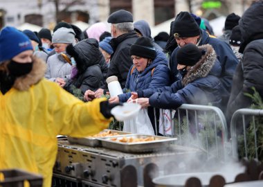Krakow, Polonya - 19 Aralık 2021: Krakow 'daki ana meydandaki fakir ve evsizler için Noel arifesi. Covid salgınına rağmen Kosciuszko grubu Krakow 'daki açık havada en büyük arifeyi hazırlıyor.