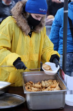 Krakow, Polonya - 19 Aralık 2021: Krakow 'daki ana meydandaki fakir ve evsizler için Noel arifesi. Covid salgınına rağmen Kosciuszko grubu Krakow 'daki açık havada en büyük arifeyi hazırlıyor.