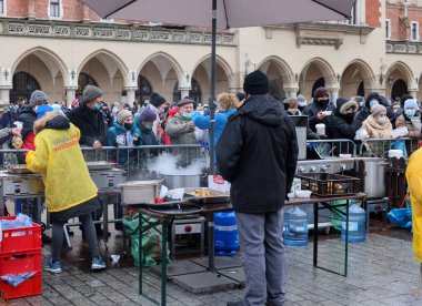 Krakow, Polonya - 19 Aralık 2021: Krakow 'daki ana meydandaki fakir ve evsizler için Noel arifesi. Covid salgınına rağmen Kosciuszko grubu Krakow 'daki açık havada en büyük arifeyi hazırlıyor.