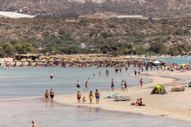 Elafonisi, Girit, Yunanistan - 19 Eylül 2021: Girit, Akdeniz 'deki Elafonisi' nin ünlü pembe mercan plajında dinlenen insanlar 