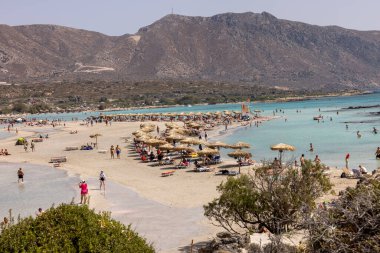 Elafonisi, Girit, Yunanistan - 19 Eylül 2021: Girit, Akdeniz 'deki Elafonisi' nin ünlü pembe mercan plajında dinlenen insanlar 