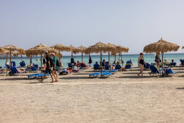 Elafonisi, Girit, Yunanistan - 19 Eylül 2021: Girit, Akdeniz 'deki Elafonisi' nin ünlü pembe mercan plajında dinlenen insanlar 
