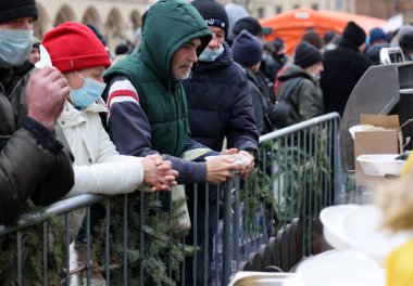 Krakow, Polonya - 19 Aralık 2021: Krakow 'daki ana meydandaki fakir ve evsizler için Noel arifesi. Covid salgınına rağmen Kosciuszko grubu Krakow 'daki açık havada en büyük arifeyi hazırlıyor.