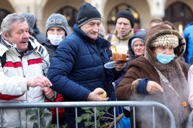Krakow, Polonya - 19 Aralık 2021: Krakow 'daki ana meydandaki fakir ve evsizler için Noel arifesi. Covid salgınına rağmen Kosciuszko grubu Krakow 'daki açık havada en büyük arifeyi hazırlıyor.