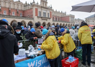 Krakow, Polonya - 19 Aralık 2021: Krakow 'daki ana meydandaki fakir ve evsizler için Noel arifesi. Covid salgınına rağmen Kosciuszko grubu Krakow 'daki açık havada en büyük arifeyi hazırlıyor.