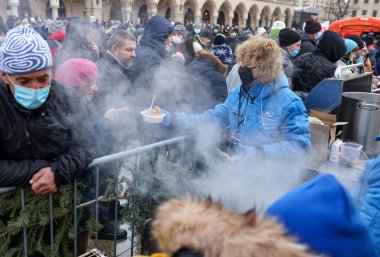 Krakow, Polonya - 19 Aralık 2021: Krakow 'daki ana meydandaki fakir ve evsizler için Noel arifesi. Covid salgınına rağmen Kosciuszko grubu Krakow 'daki açık havada en büyük arifeyi hazırlıyor.