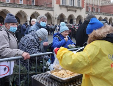 Krakow, Polonya - 19 Aralık 2021: Krakow 'daki ana meydandaki fakir ve evsizler için Noel arifesi. Covid salgınına rağmen Kosciuszko grubu Krakow 'daki açık havada en büyük arifeyi hazırlıyor.