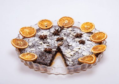 Haşhaş tohumlu tart ve üzerine toz şeker serpiştirilmiş meyve.