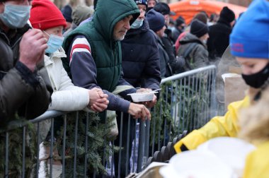 Krakow, Polonya - 19 Aralık 2021: Krakow 'daki ana meydandaki fakir ve evsizler için Noel arifesi. Covid salgınına rağmen Kosciuszko grubu Krakow 'daki açık havada en büyük arifeyi hazırlıyor.