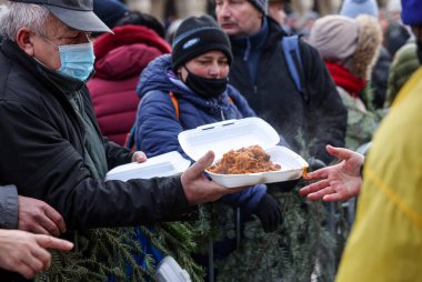 Krakow, Polonya - 19 Aralık 2021: Krakow 'daki ana meydandaki fakir ve evsizler için Noel arifesi. Covid salgınına rağmen Kosciuszko grubu Krakow 'daki açık havada en büyük arifeyi hazırlıyor.
