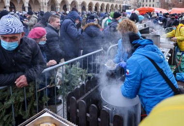 Krakow, Polonya - 19 Aralık 2021: Krakow 'daki ana meydandaki fakir ve evsizler için Noel arifesi. Covid salgınına rağmen Kosciuszko grubu Krakow 'daki açık havada en büyük arifeyi hazırlıyor.