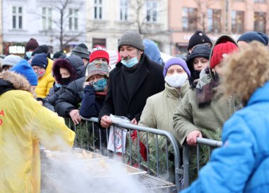 Krakow, Polonya - 19 Aralık 2021: Krakow 'daki ana meydandaki fakir ve evsizler için Noel arifesi. Covid salgınına rağmen Kosciuszko grubu Krakow 'daki açık havada en büyük arifeyi hazırlıyor.