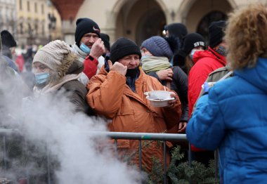 Krakow, Polonya - 19 Aralık 2021: Krakow 'daki ana meydandaki fakir ve evsizler için Noel arifesi. Covid salgınına rağmen Kosciuszko grubu Krakow 'daki açık havada en büyük arifeyi hazırlıyor.