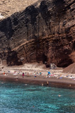 Santorini, Yunanistan - 01 Temmuz 2021: Santorini adasının güney kıyısındaki ünlü Kızıl Kumsal, Kiklad, Ege Denizi.