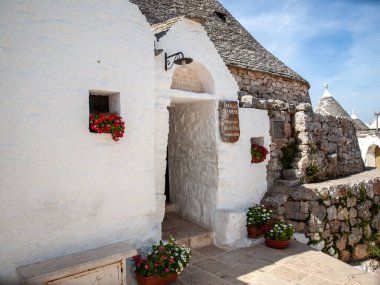 Alberobello, İtalya - 16 Eylül 2019: Trulli köyünde geleneksel beyaz evler. Alberobello, İtalya. Yapım tarzı İtalya 'nın Apulia bölgesindeki Murge bölgesine özgüdür (İtalyan Puglia bölgesinde). Kireç taşı ve temel taştan yapılmış..