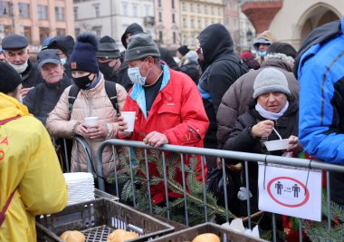 Krakow, Polonya - 19 Aralık 2021: Krakow 'daki ana meydandaki fakir ve evsizler için Noel arifesi. Covid salgınına rağmen Kosciuszko grubu Krakow 'daki açık havada en büyük arifeyi hazırlıyor.