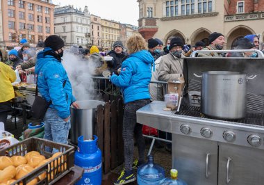 Krakow, Polonya - 19 Aralık 2021: Krakow 'daki ana meydandaki fakir ve evsizler için Noel arifesi. Covid salgınına rağmen Kosciuszko grubu Krakow 'daki açık havada en büyük arifeyi hazırlıyor.