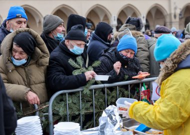 Krakow, Polonya - 19 Aralık 2021: Krakow 'daki ana meydandaki fakir ve evsizler için Noel arifesi. Covid salgınına rağmen Kosciuszko grubu Krakow 'daki açık havada en büyük arifeyi hazırlıyor.