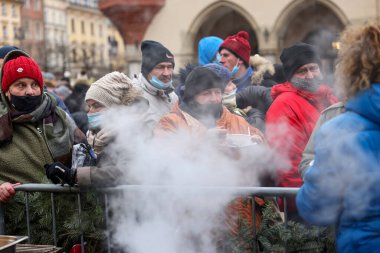 Krakow, Polonya - 19 Aralık 2021: Krakow 'daki ana meydandaki fakir ve evsizler için Noel arifesi. Covid salgınına rağmen Kosciuszko grubu Krakow 'daki açık havada en büyük arifeyi hazırlıyor.