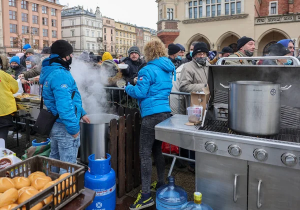 Krakow, Polonya - 19 Aralık 2021: Krakow 'daki ana meydandaki fakir ve evsizler için Noel arifesi. Covid salgınına rağmen Kosciuszko grubu Krakow 'daki açık havada en büyük arifeyi hazırlıyor.