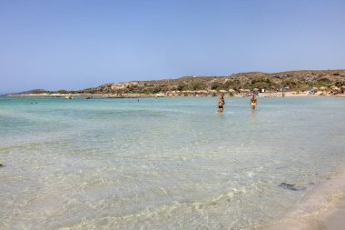 Elafonisi, Girit, Yunanistan - 19 Eylül 2021: Girit, Akdeniz 'deki Elafonisi' nin ünlü pembe mercan plajında dinlenen insanlar 