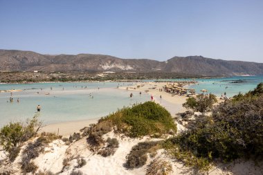 Elafonisi, Girit, Yunanistan - 19 Eylül 2021: Girit, Akdeniz 'deki Elafonisi' nin ünlü pembe mercan plajında dinlenen insanlar 