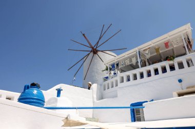 Oia, Santorini, Yunanistan - 3 Temmuz 2021: Santorini adasındaki geleneksel beyaz yel değirmeni. Cyclades, Yunanistan 