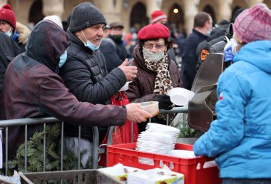 Krakow, Polonya - 19 Aralık 2021: Krakow 'daki ana meydandaki fakir ve evsizler için Noel arifesi. Covid salgınına rağmen Kosciuszko grubu Krakow 'daki açık havada en büyük arifeyi hazırlıyor.
