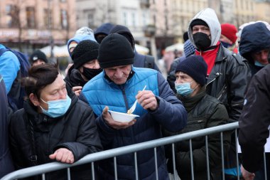Krakow, Polonya - 19 Aralık 2021: Krakow 'daki ana meydandaki fakir ve evsizler için Noel arifesi. Covid salgınına rağmen Kosciuszko grubu Krakow 'daki açık havada en büyük arifeyi hazırlıyor.