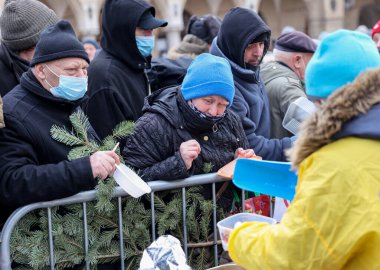 Krakow, Polonya - 19 Aralık 2021: Krakow 'daki ana meydandaki fakir ve evsizler için Noel arifesi. Covid salgınına rağmen Kosciuszko grubu Krakow 'daki açık havada en büyük arifeyi hazırlıyor.