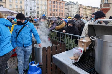 Krakow, Polonya - 19 Aralık 2021: Krakow 'daki ana meydandaki fakir ve evsizler için Noel arifesi. Covid salgınına rağmen Kosciuszko grubu Krakow 'daki açık havada en büyük arifeyi hazırlıyor.