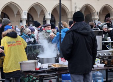 Krakow, Polonya - 19 Aralık 2021: Krakow 'daki ana meydandaki fakir ve evsizler için Noel arifesi. Covid salgınına rağmen Kosciuszko grubu Krakow 'daki açık havada en büyük arifeyi hazırlıyor.