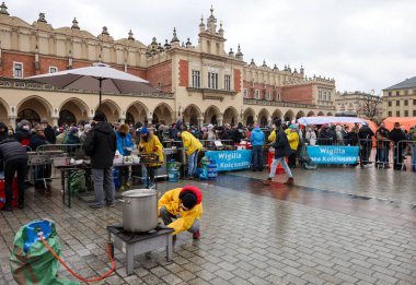 Krakow, Polonya - 19 Aralık 2021: Krakow 'daki ana meydandaki fakir ve evsizler için Noel arifesi. Covid salgınına rağmen Kosciuszko grubu Krakow 'daki açık havada en büyük arifeyi hazırlıyor.