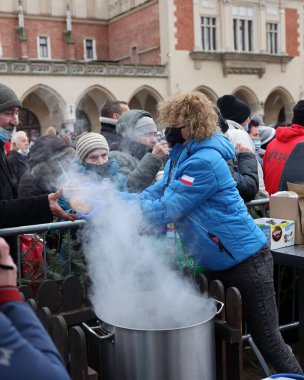Krakow, Polonya - 19 Aralık 2021: Krakow 'daki ana meydandaki fakir ve evsizler için Noel arifesi. Covid salgınına rağmen Kosciuszko grubu Krakow 'daki açık havada en büyük arifeyi hazırlıyor.