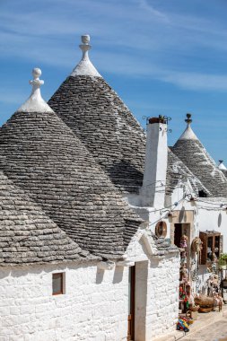 Alberobello, İtalya - 16 Eylül 2019: Trulli köyünde geleneksel beyaz evler. Alberobello, İtalya. Yapım tarzı İtalya 'nın Apulia bölgesindeki Murge bölgesine özgüdür (İtalyan Puglia bölgesinde). Kireç taşı ve temel taştan yapılmış..