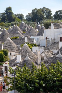 Alberobello, İtalya - 16 Eylül 2019: Trulli köyünde geleneksel beyaz evler. Alberobello, İtalya. Yapım tarzı İtalya 'nın Apulia bölgesindeki Murge bölgesine özgüdür (İtalyan Puglia bölgesinde). Kireç taşı ve temel taştan yapılmış..