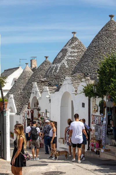 Alberobello, İtalya - 16 Eylül 2019: Halk Alberobello, İtalya 'daki Trulli köyünü ziyaret etti. Yapım tarzı İtalya 'nın Apulia bölgesindeki Murge bölgesine özgüdür (İtalyan Puglia bölgesinde). Kireç taşı ve temel taştan yapılmış..