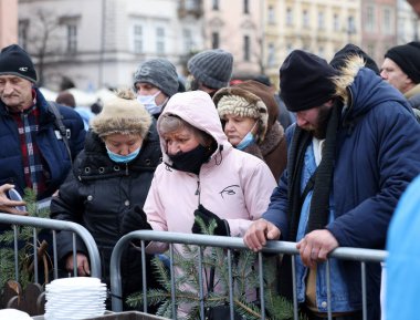 Krakow, Polonya - 19 Aralık 2021: Krakow 'daki ana meydandaki fakir ve evsizler için Noel arifesi. Covid salgınına rağmen Kosciuszko grubu Krakow 'daki açık havada en büyük arifeyi hazırlıyor.