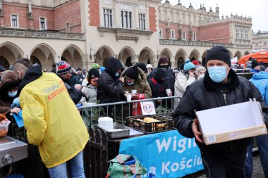 Krakow, Polonya - 19 Aralık 2021: Krakow 'daki ana meydandaki fakir ve evsizler için Noel arifesi. Covid salgınına rağmen Kosciuszko grubu Krakow 'daki açık havada en büyük arifeyi hazırlıyor.