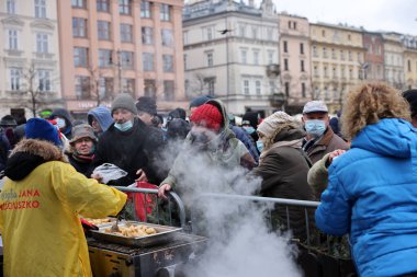 Krakow, Polonya - 19 Aralık 2021: Krakow 'daki ana meydandaki fakir ve evsizler için Noel arifesi. Covid salgınına rağmen Kosciuszko grubu Krakow 'daki açık havada en büyük arifeyi hazırlıyor.