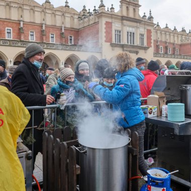 Krakow, Polonya - 19 Aralık 2021: Krakow 'daki ana meydandaki fakir ve evsizler için Noel arifesi. Covid salgınına rağmen Kosciuszko grubu Krakow 'daki açık havada en büyük arifeyi hazırlıyor.