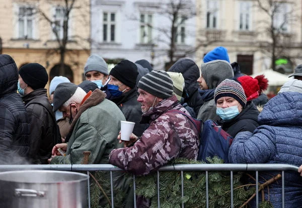 Krakow, Polonya - 19 Aralık 2021: Krakow 'daki ana meydandaki fakir ve evsizler için Noel arifesi. Covid salgınına rağmen Kosciuszko grubu Krakow 'daki açık havada en büyük arifeyi hazırlıyor.