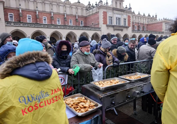 Krakow, Polonya - 19 Aralık 2021: Krakow 'daki ana meydandaki fakir ve evsizler için Noel arifesi. Covid salgınına rağmen Kosciuszko grubu Krakow 'daki açık havada en büyük arifeyi hazırlıyor.