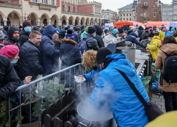 Krakow, Polonya - 19 Aralık 2021: Krakow 'daki ana meydandaki fakir ve evsizler için Noel arifesi. Covid salgınına rağmen Kosciuszko grubu Krakow 'daki açık havada en büyük arifeyi hazırlıyor.