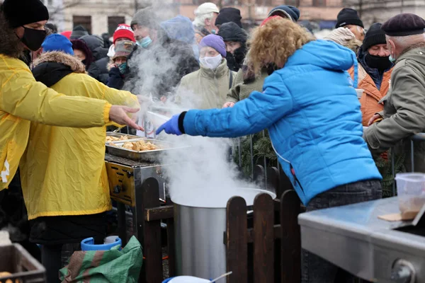 Krakow, Polonya - 19 Aralık 2021: Krakow 'daki ana meydandaki fakir ve evsizler için Noel arifesi. Covid salgınına rağmen Kosciuszko grubu Krakow 'daki açık havada en büyük arifeyi hazırlıyor.