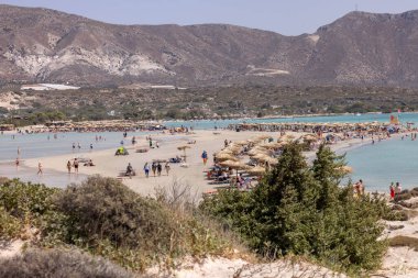 Elafonisi, Girit, Yunanistan - 19 Eylül 2021: Girit, Akdeniz 'deki Elafonisi' nin ünlü pembe mercan plajında dinlenen insanlar 