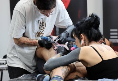 Krakow, Polonya - 11 Haziran 2022: 15 Krakow Dövme Festivali. En prestijli dövme festivallerinden biri. Dövmeci iş başında. Dövme işlemi..